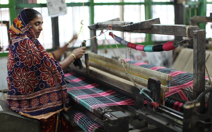 Een vrouw weeft stoffen voor het fair trade merk People Tree
